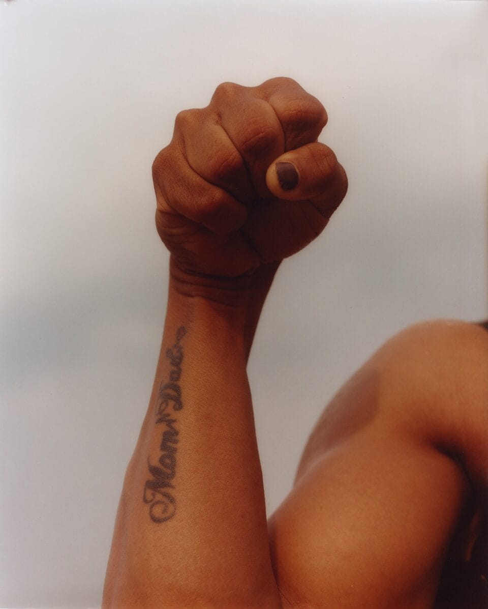 a tattooed arm holds up a fist