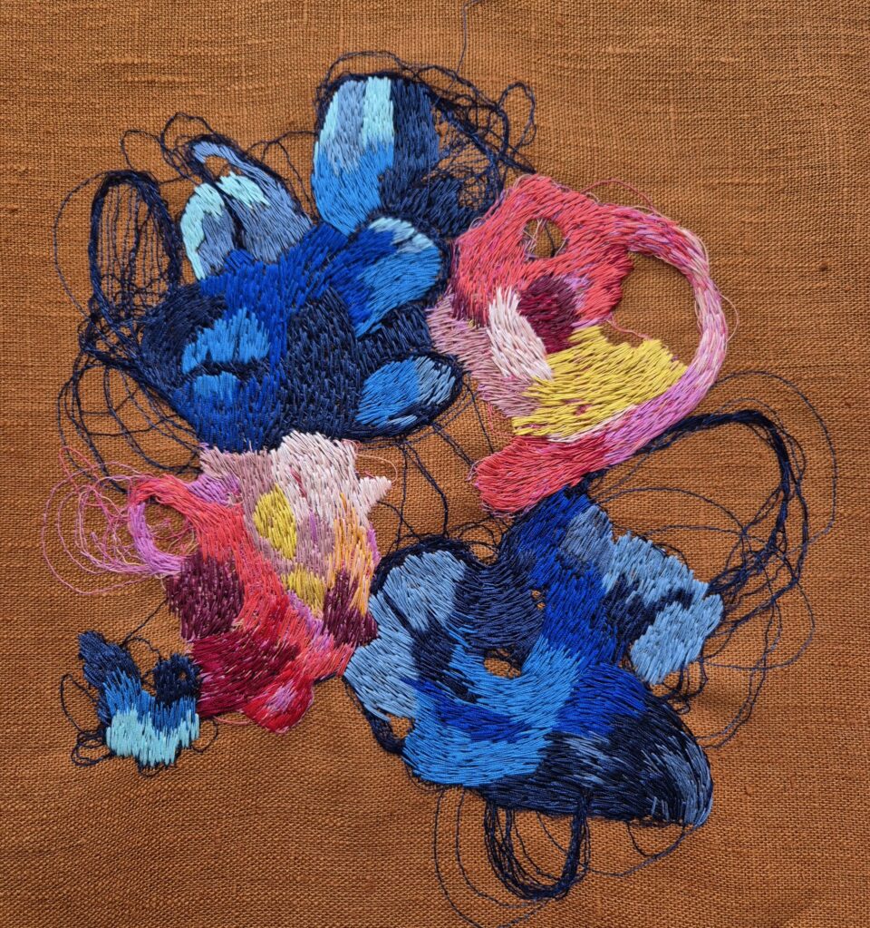 a colorful abstract embroidery on brown fabric